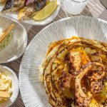 Delicious fine dining seafood platter featuring grilled octopus and fresh sides served on elegant tableware.